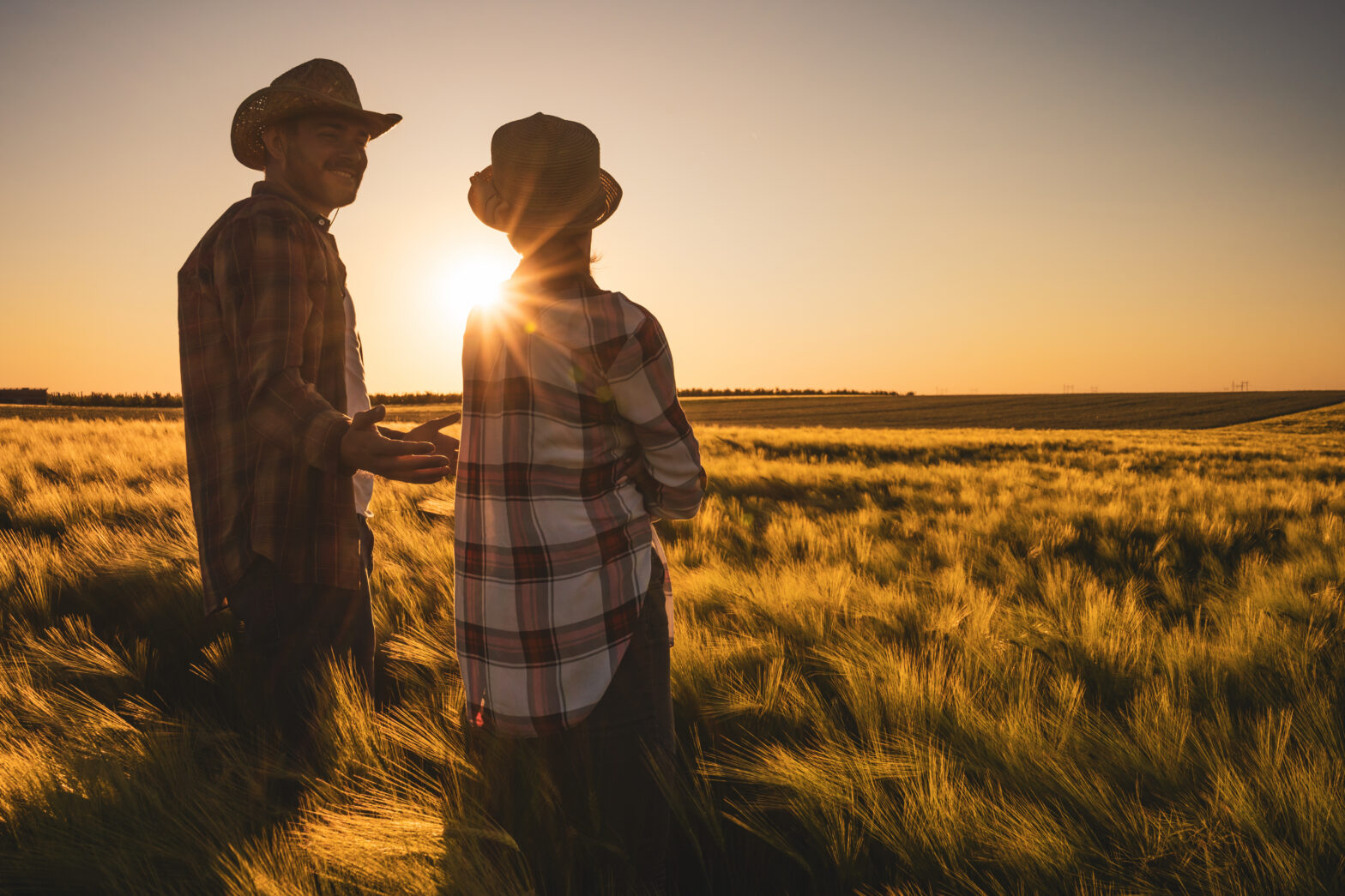 Farmer and son walking in a field at sunset