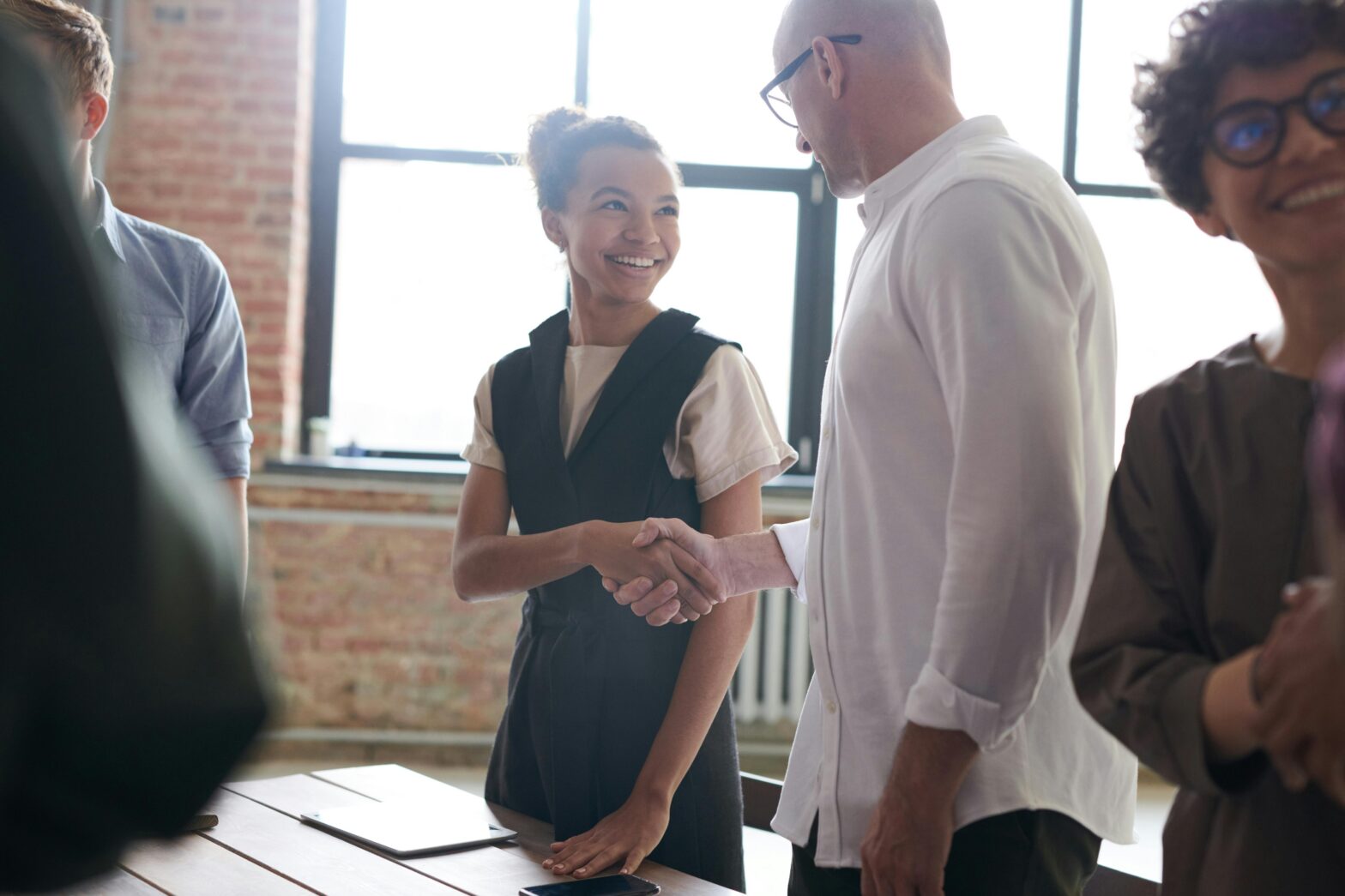 Two coworkers shaking hands, agreeing on a partnership.