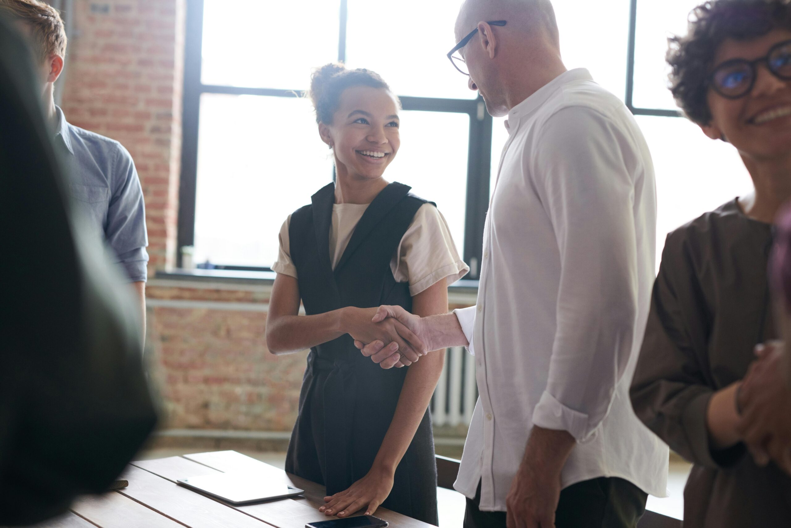 Two coworkers shaking hands, agreeing on a partnership.